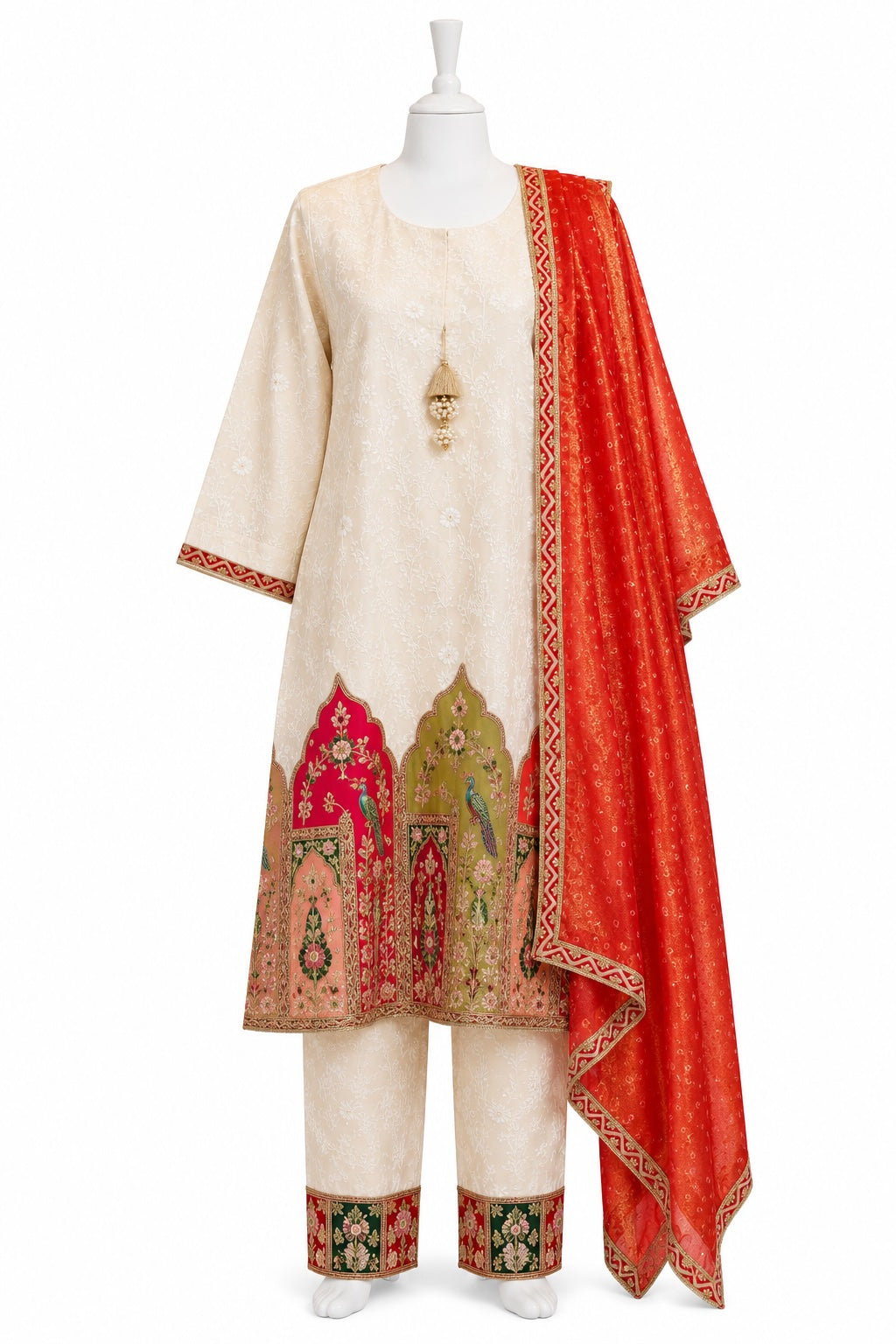 Traditional outfit with a cream kurta, red dupatta, and embroidered pants on a mannequin against a white background.