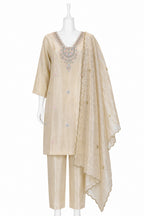 Beige embroidered traditional outfit on a mannequin against a white background