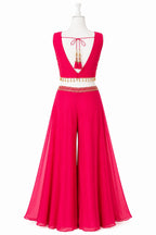 Pink evening gown with gold embellishments on a mannequin against a white background
