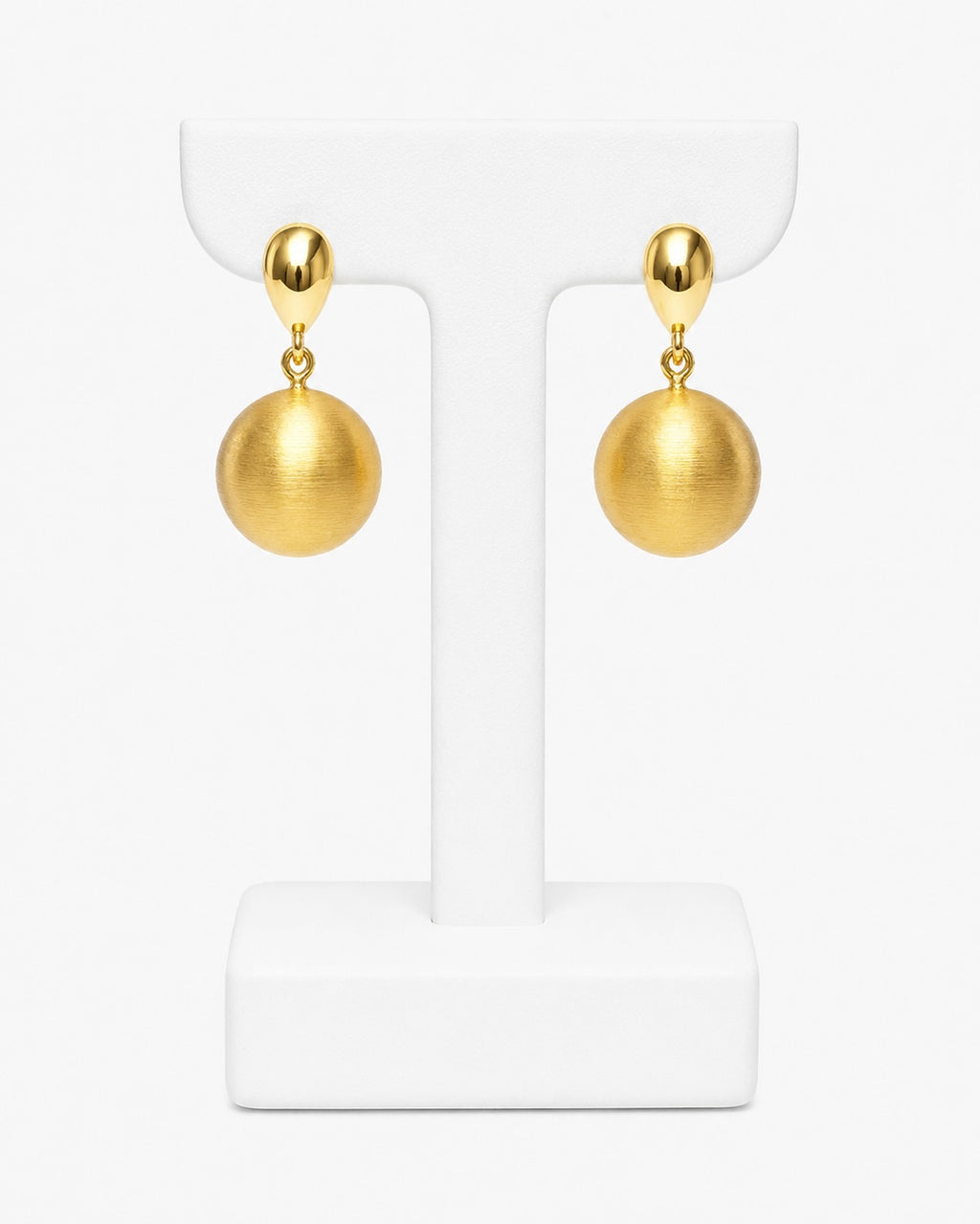 A pair of gold drop earrings with spherical dangling charms, displayed on a white T-shaped jewelry stand against a clean white background.