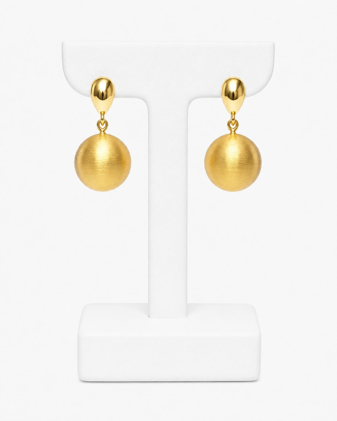 A pair of gold drop earrings with spherical dangling charms, displayed on a white T-shaped jewelry stand against a clean white background.