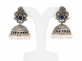Pair of silver jhumka earrings with blue stones on a white background