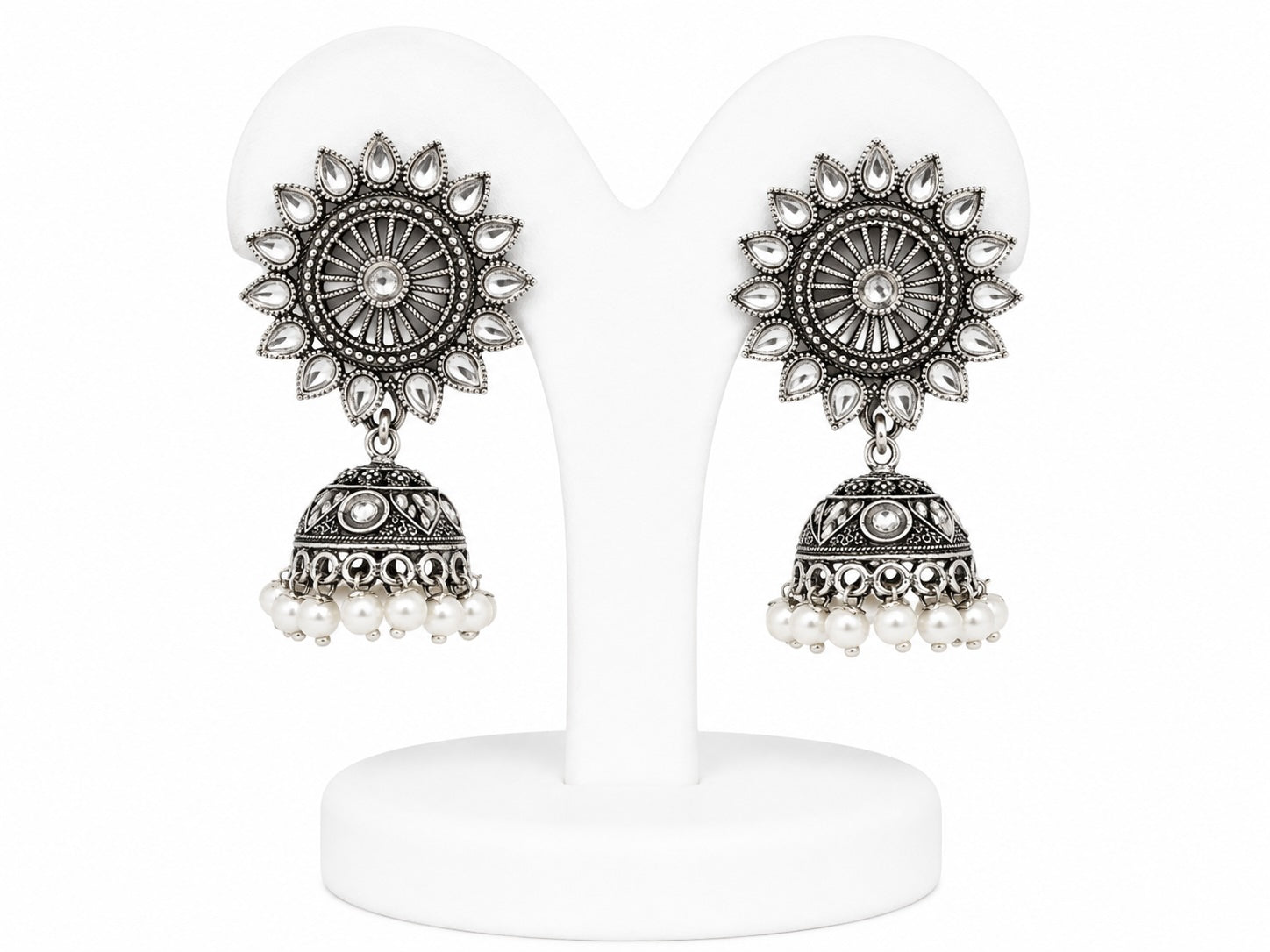 Pair of silver and pearl earrings on a white stand
