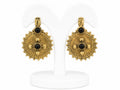 Pair of gold earrings with black gemstones on a white stand