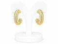 Gold hoop earrings on a white stand against a white background