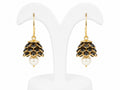 Pair of earrings with black gemstones and pearl drops on a white background