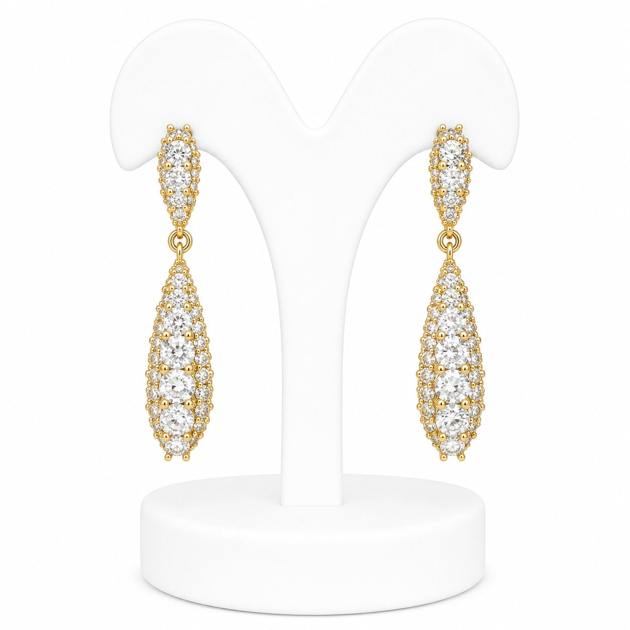 Gold earrings with clear stones on a white stand