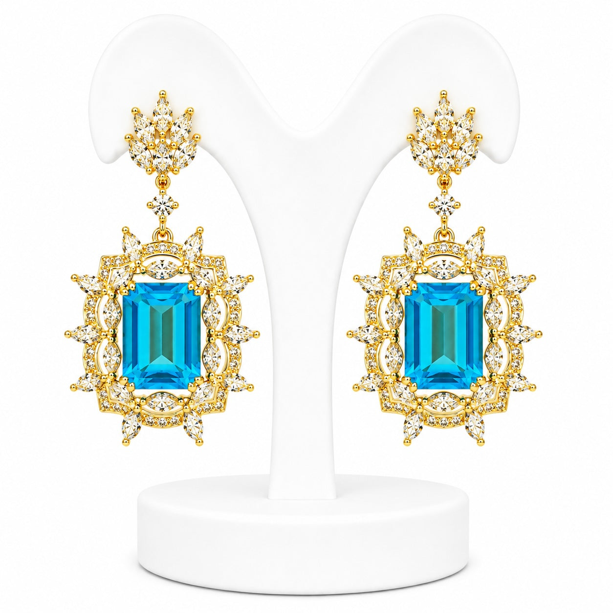 Pair of gold earrings with blue gemstones on a white background