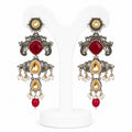 Ornate earrings with red gemstones and gold accents on a white background