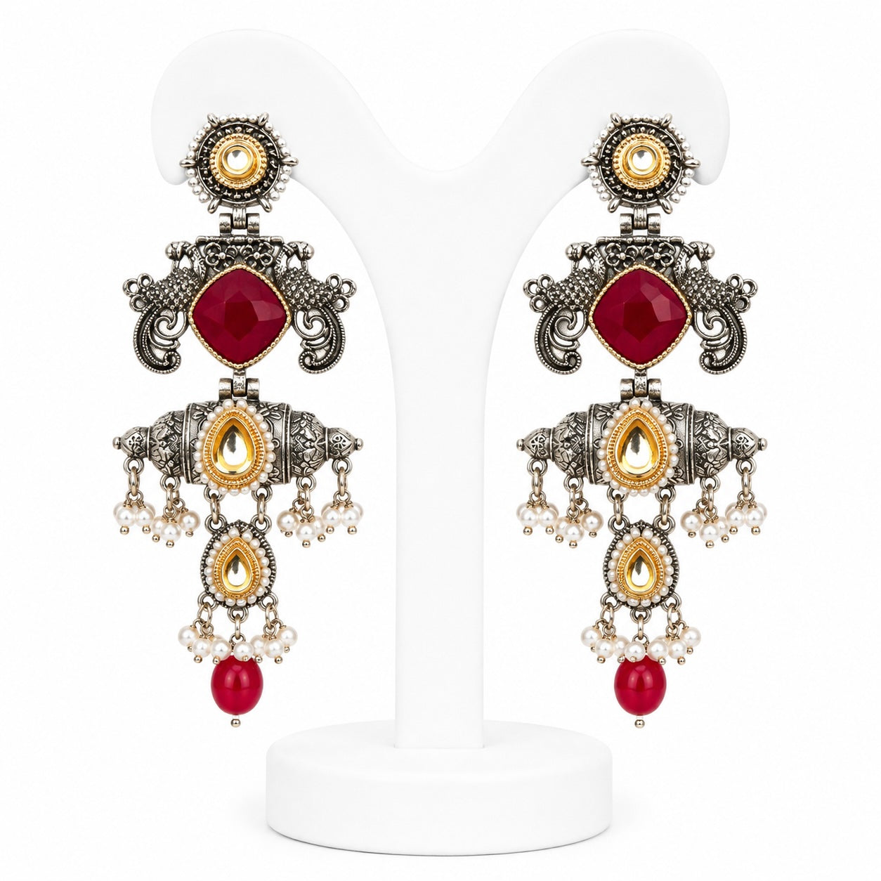 Ornate earrings with red gemstones and gold accents on a white background