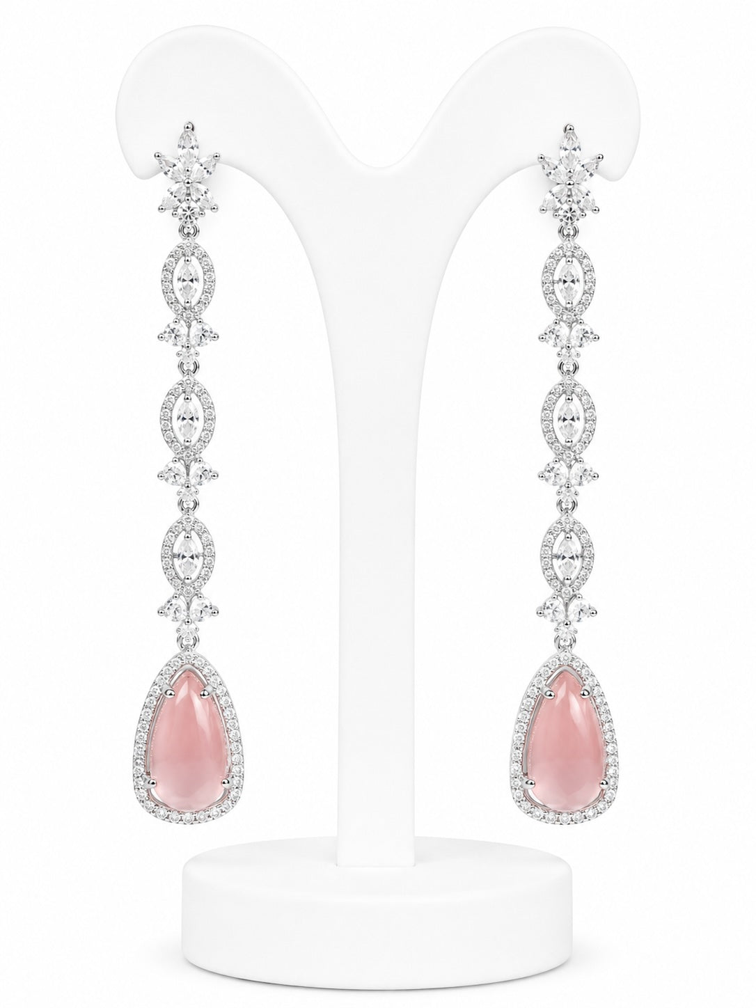 Pair of pink teardrop earrings with silver and diamond accents on a white stand.