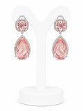 Pink teardrop earrings on a white stand with a white background