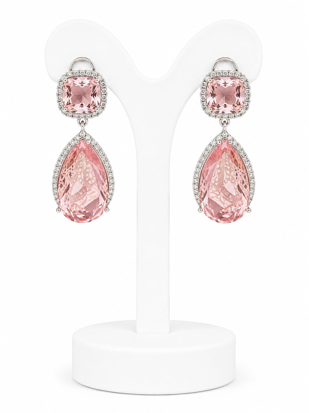 Pink teardrop earrings on a white stand with a white background