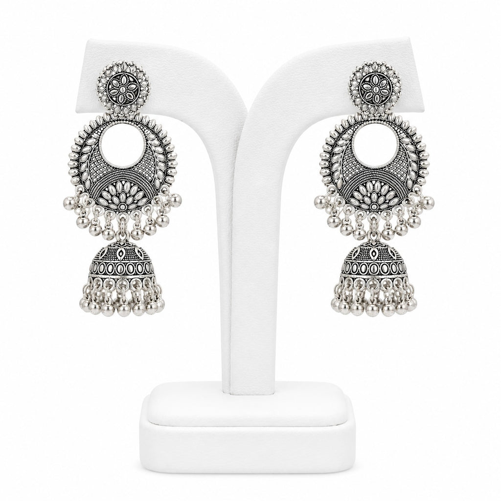 Pair of silver earrings on a white stand with a white background