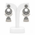 Pair of silver earrings on a white stand with a white background