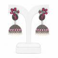 Pair of pink and silver earrings on a white stand