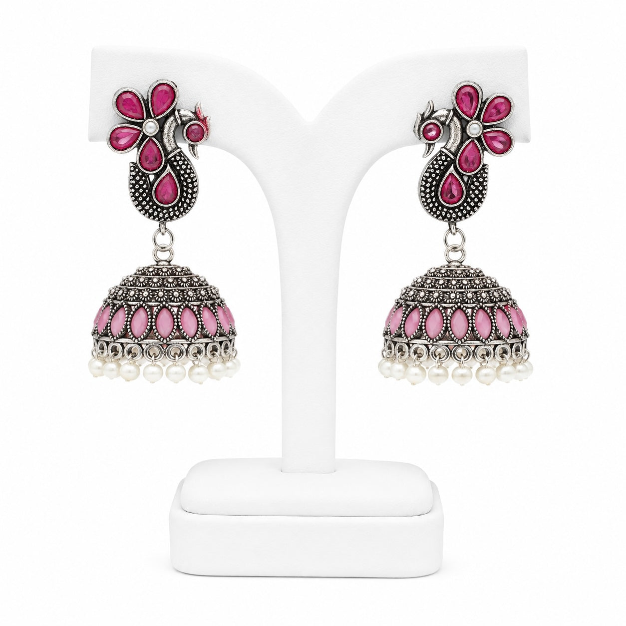 Pair of pink and silver earrings on a white stand