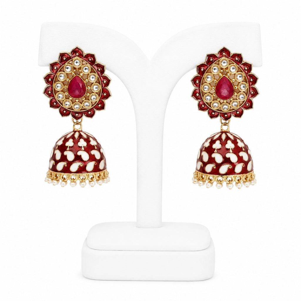 Pair of red and gold earrings on a white stand