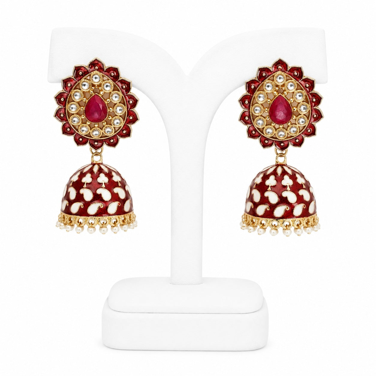 Pair of red and gold earrings on a white stand