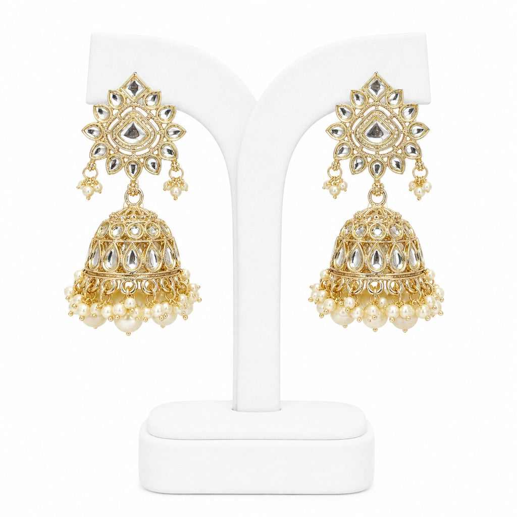 Gold and pearl earrings on a white stand