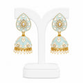 Decorative earrings on a white stand with a light blue and gold design.