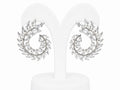 Pair of silver earrings with leaf-like design on a white background