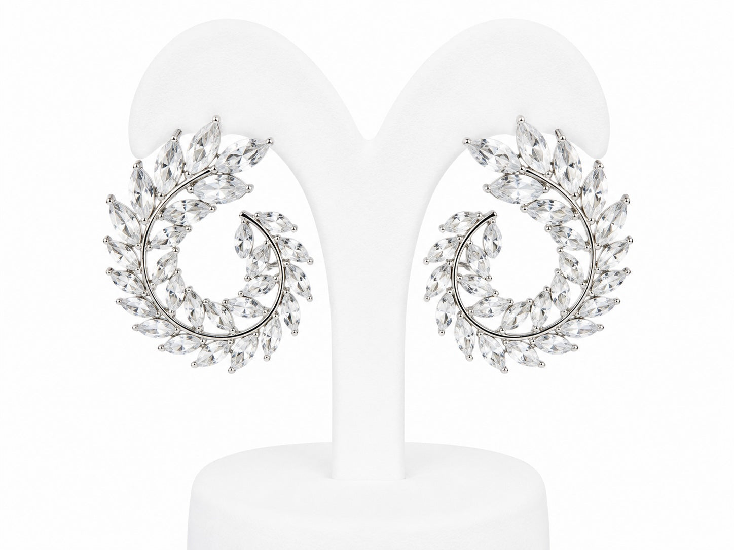Pair of silver earrings with leaf-like design on a white background