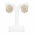 Gold and diamond earrings on a white stand with a white background
