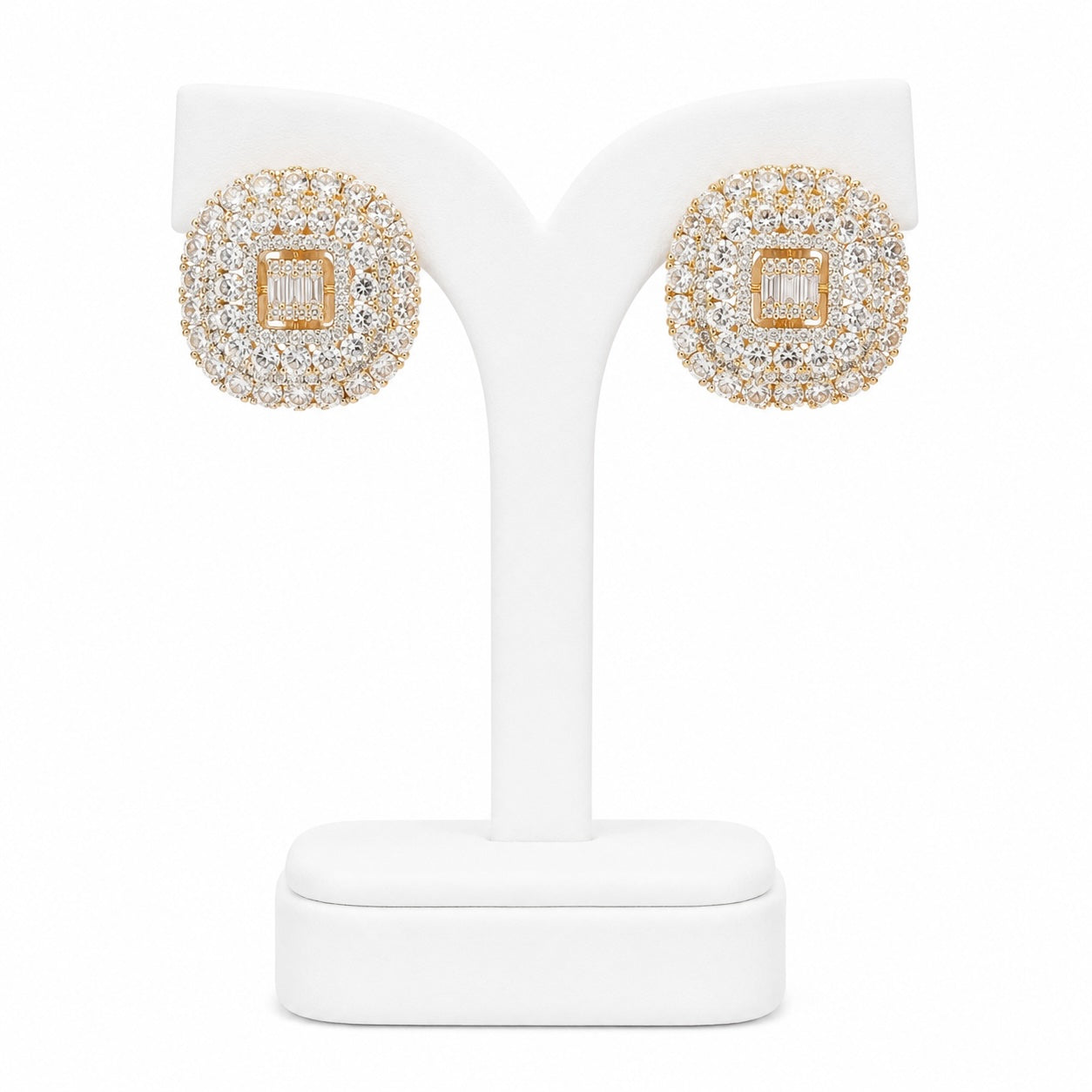 Gold and diamond earrings on a white stand with a white background