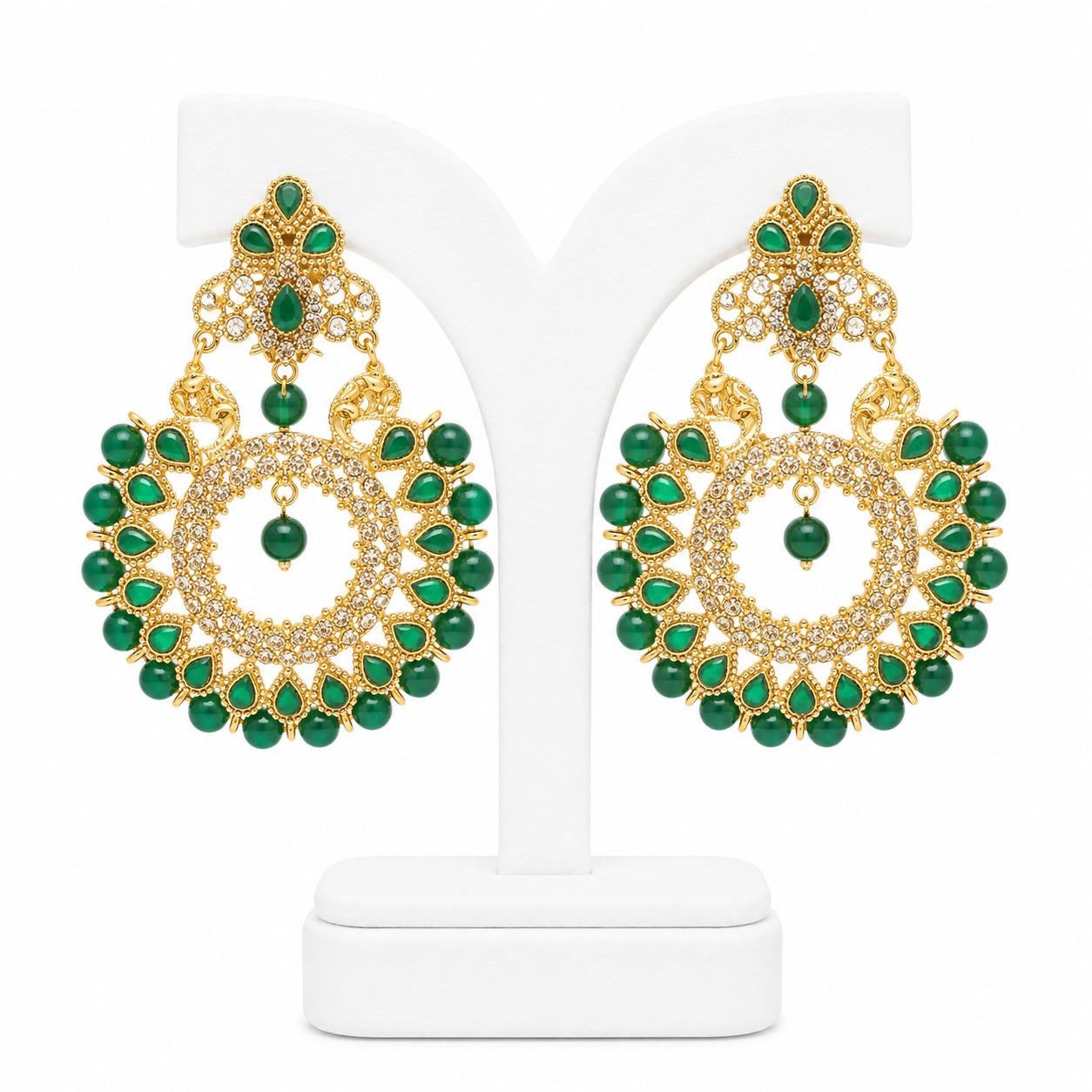 Gold and green earrings on a white stand