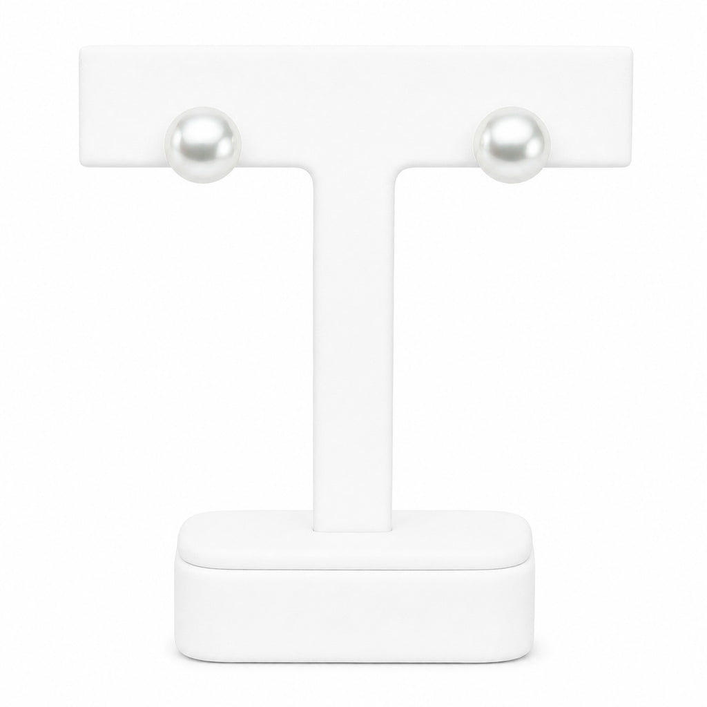 Pair of pearl earrings on a white stand with a white background