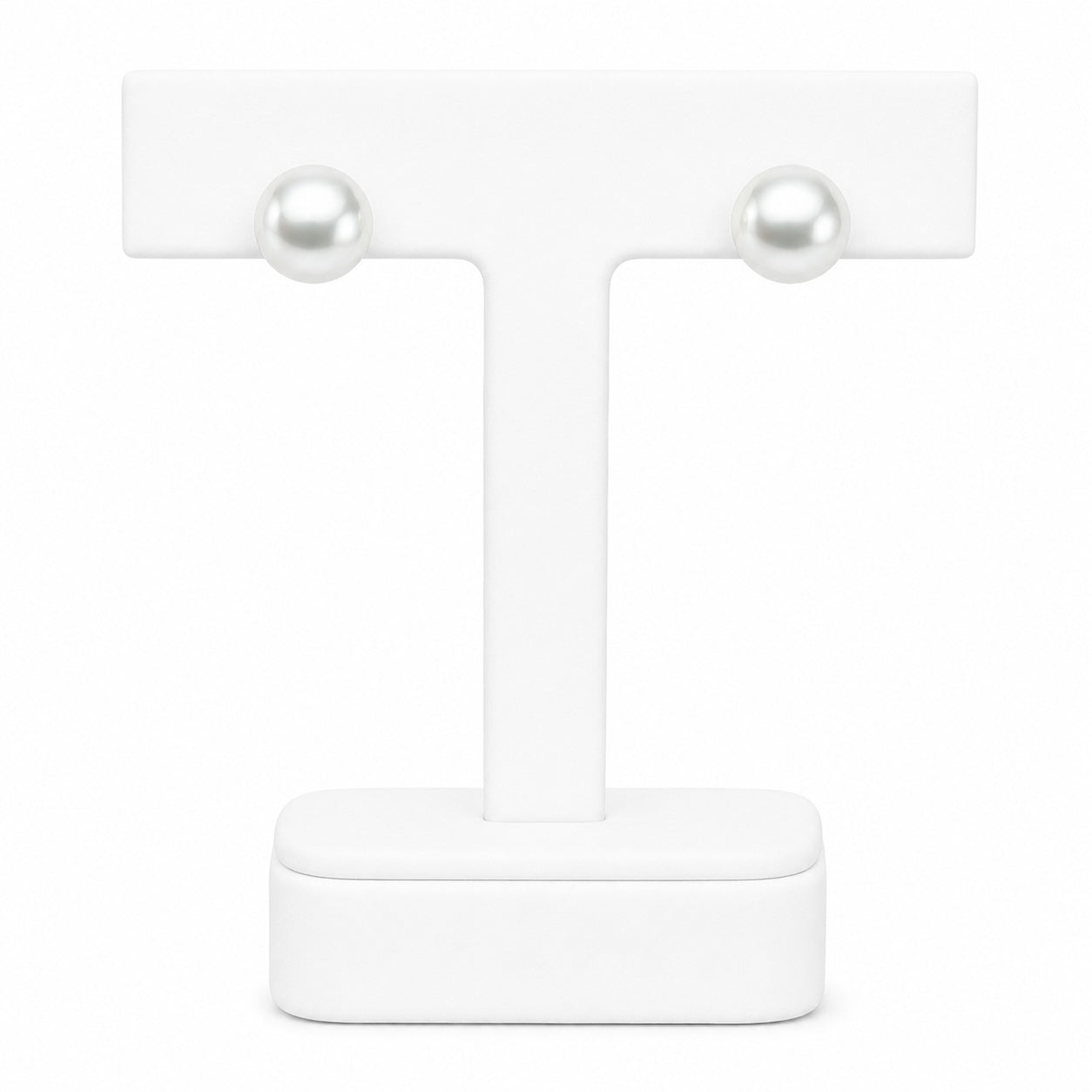 Pair of pearl earrings on a white stand with a white background