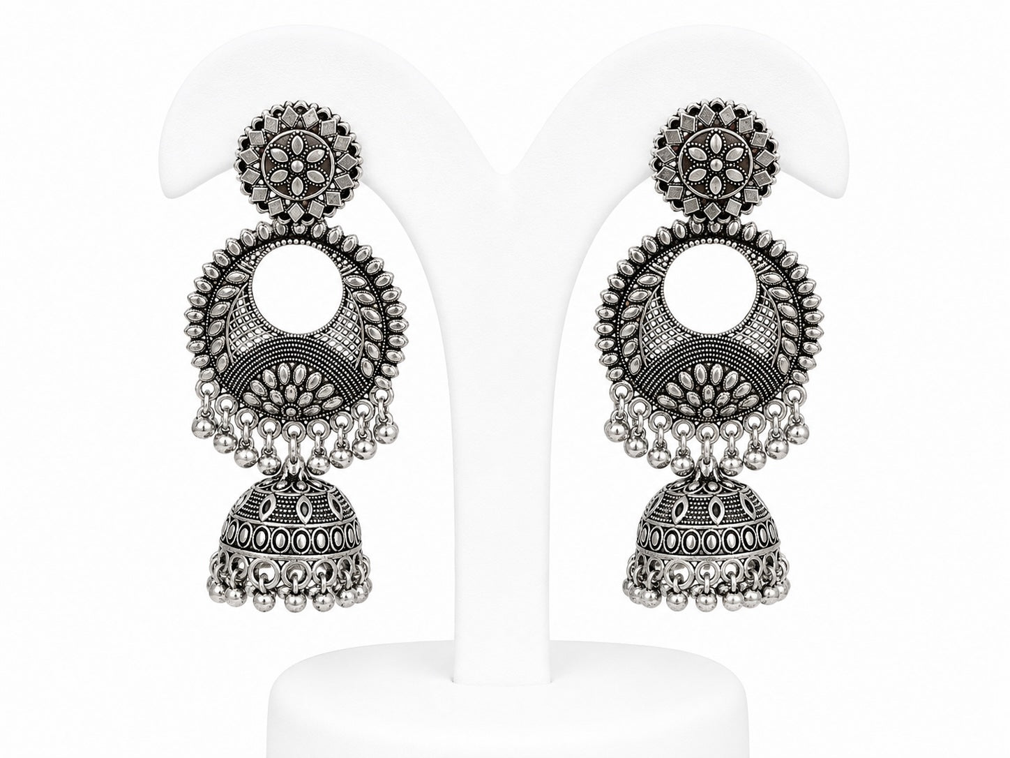 Pair of silver earrings with intricate designs on a white background