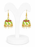 Pair of gold and green earrings on a white stand