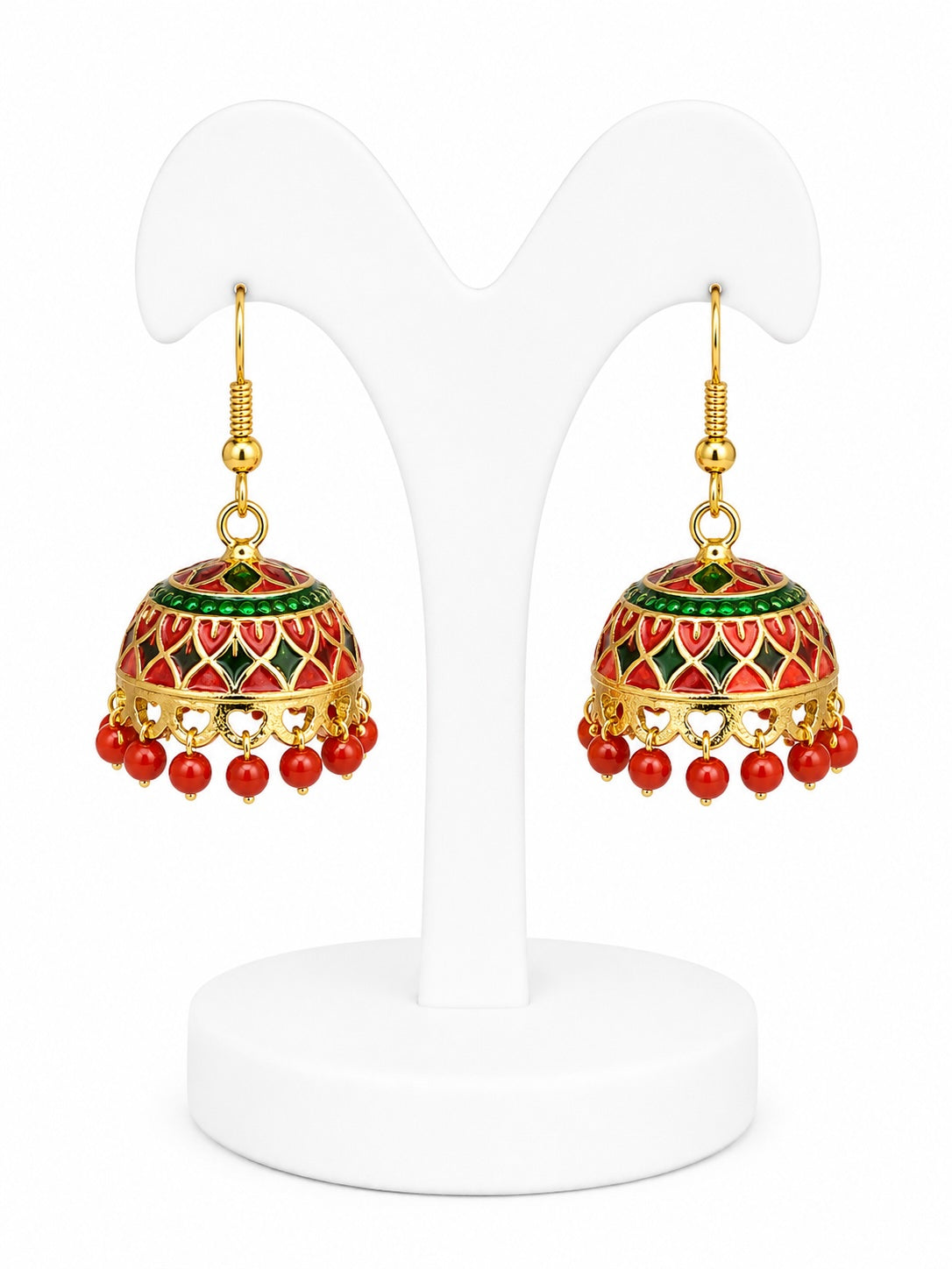 Pair of gold earrings with red and green accents on a white stand