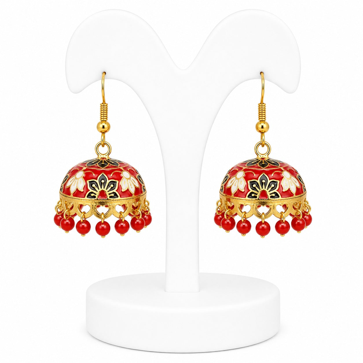 Pair of red and gold earrings on a white stand