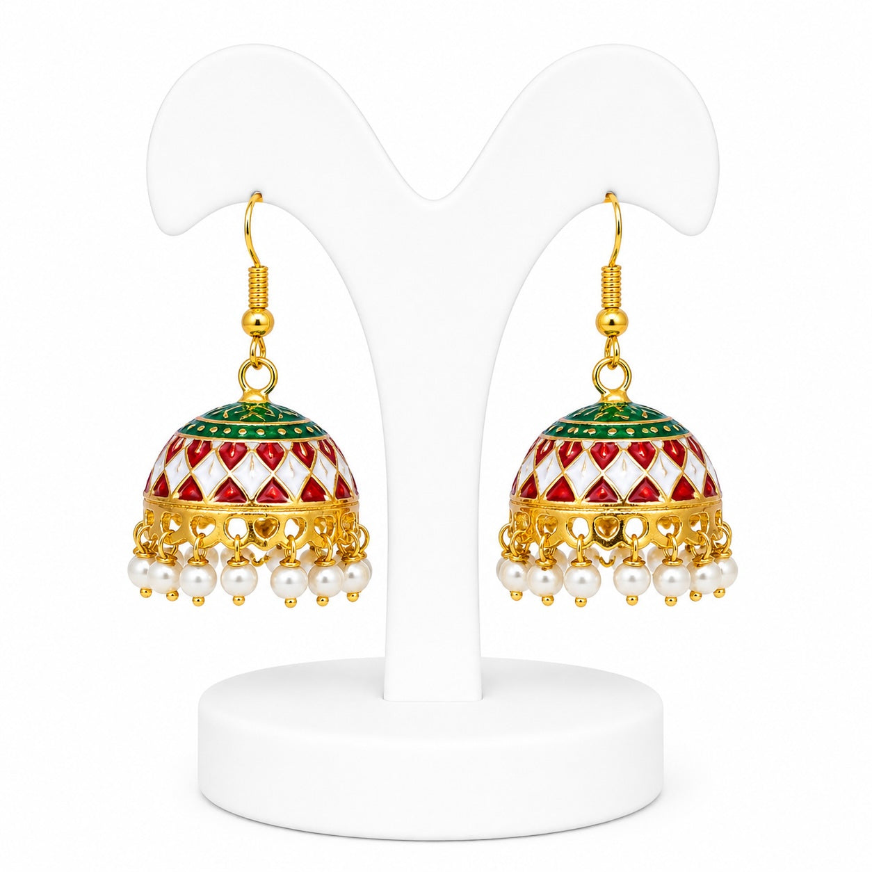 Pair of gold earrings with red, green, and white patterns on a white stand.