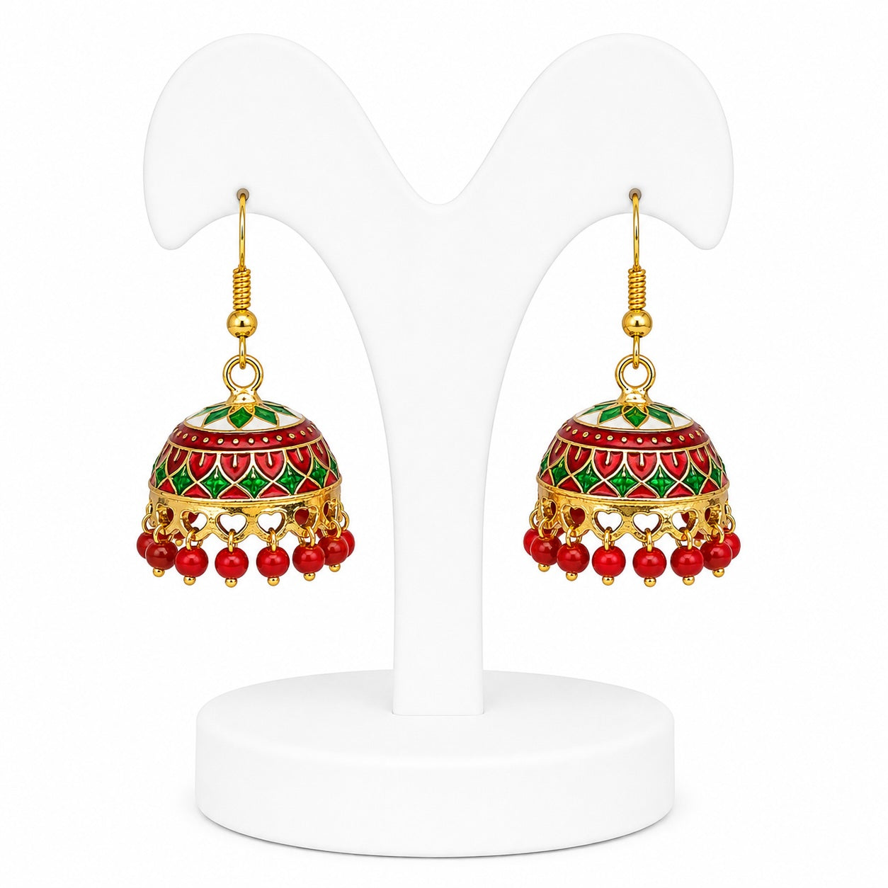 Pair of decorative earrings with red and green details on a white stand.