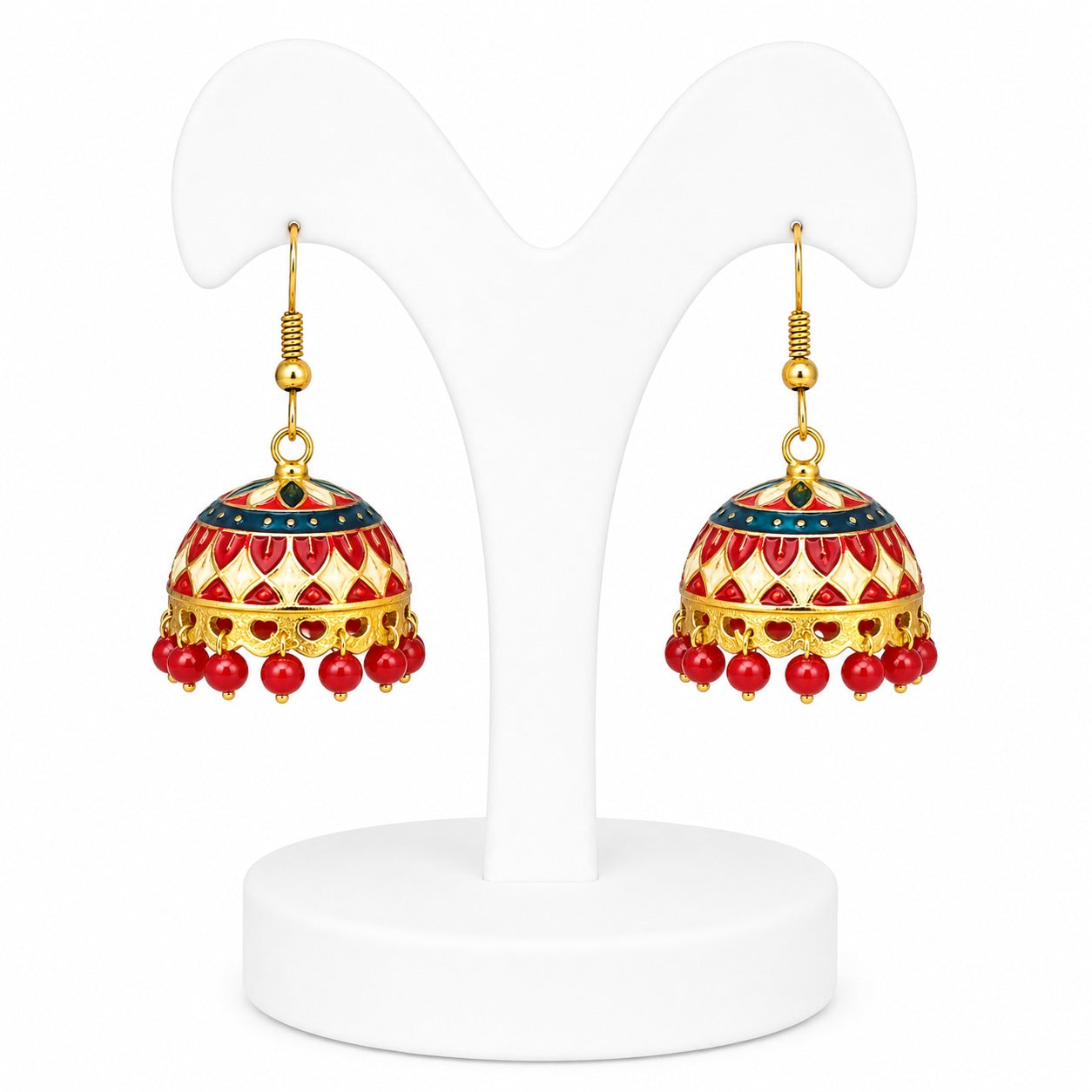 Pair of red and gold earrings on a white stand