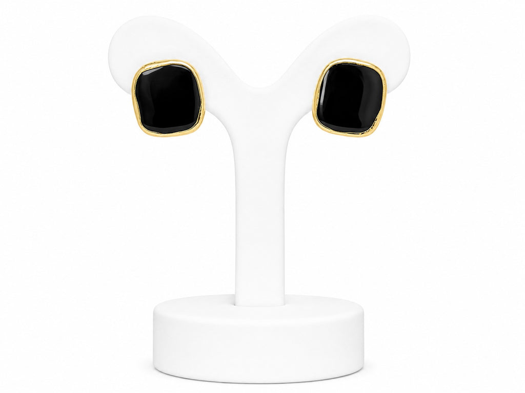 Pair of black square earrings with gold accents on a white stand.
