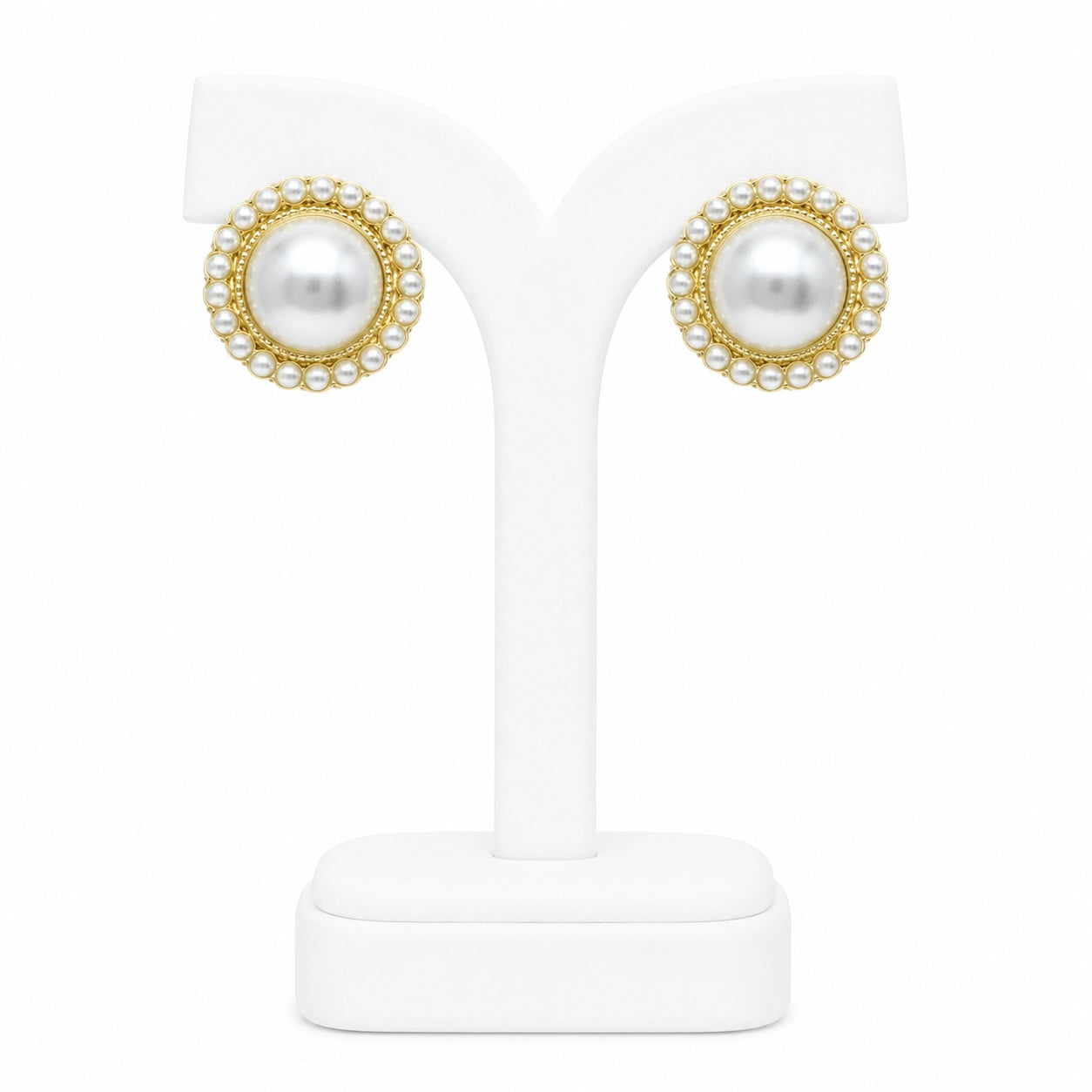 Pearl earrings with gold accents on a white stand