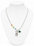 Necklace with colorful beads and a teddy bear pendant on a white mannequin.