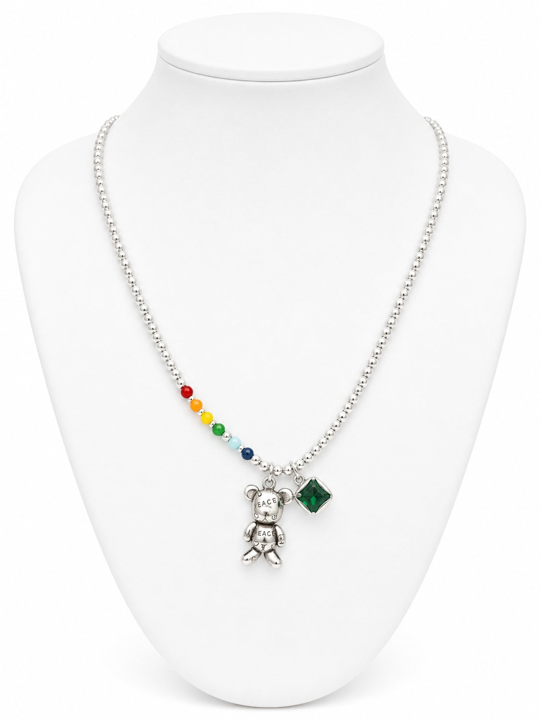 Necklace with colorful beads and a teddy bear pendant on a white mannequin.