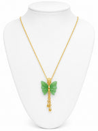 Gold necklace with a green butterfly pendant on a white mannequin bust.