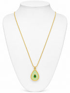 Gold necklace with a green teardrop pendant on a white mannequin bust.