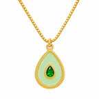 Gold necklace with a green teardrop pendant on a white background