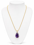 Gold necklace with a purple teardrop pendant on a white mannequin bust.