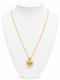 Gold heart-shaped necklace on a white mannequin bust