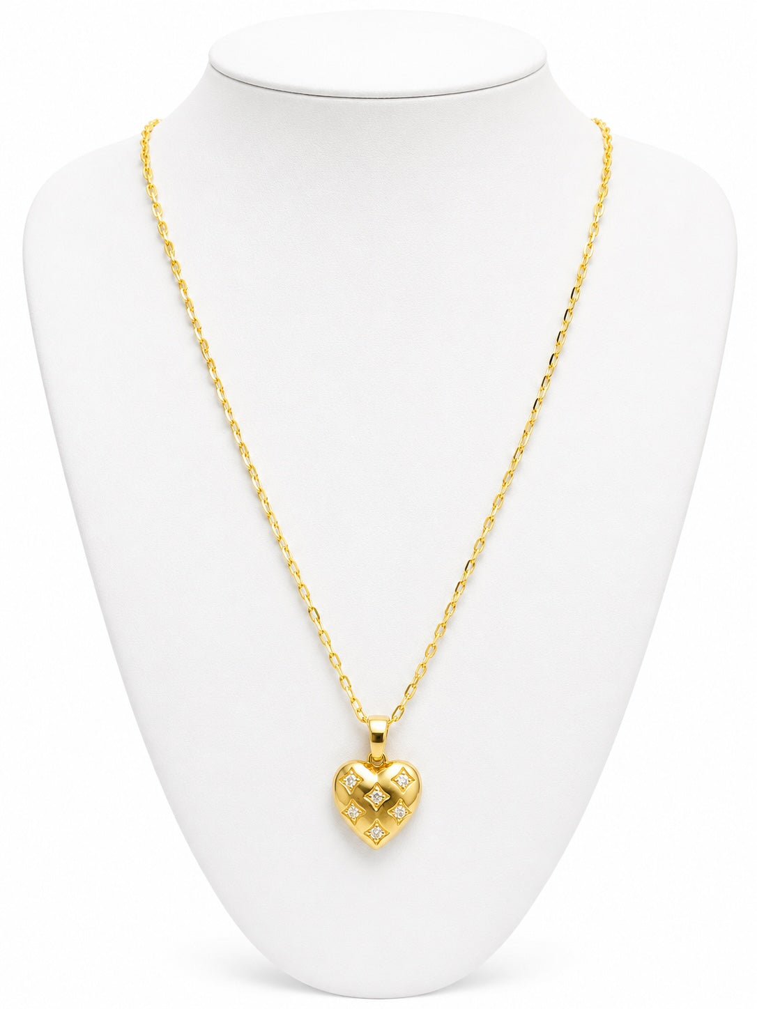 Gold heart-shaped necklace on a white mannequin bust