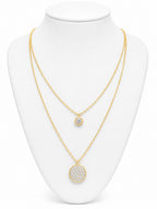 Gold necklace with circular pendants on a white mannequin bust